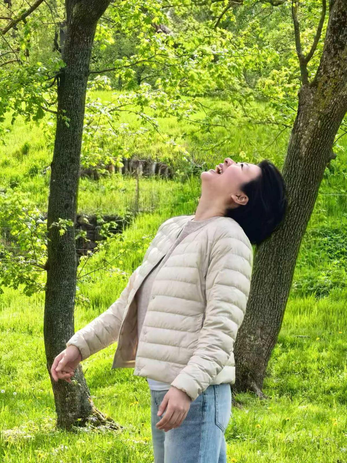 Sisi Chen lächelt in einer grünen Landschaft